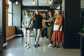 Fototapeta premium Successful female designers smiling at the camera in an office
