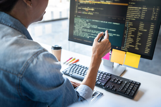 Two professional programmer cooperating and working on web site project in a software developing on desktop computer at company, codes and typing data code, Programming with HTML, PHP and javascript