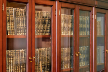 Wardrobe with old books on shelves and glass doors
