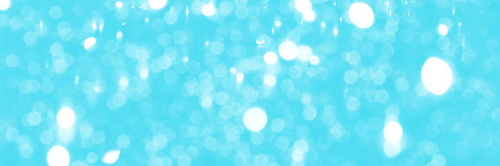 Bright blue sparkling glitter bokeh background, banner texture. Abstract defocused lights header. Wide screen wallpaper. Panoramic web banner with copy space for design