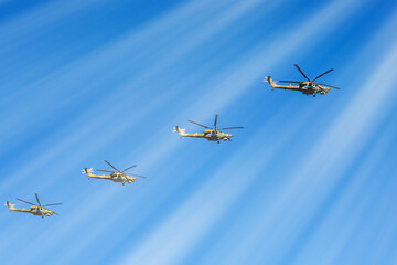 Military helicopters are flying in the sky .