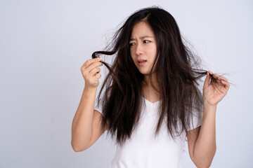 Portrait of a girl with damaged hair. She's having a problem with messy hair on a white background.
