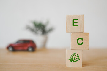 ECO word ,earth instead of O, on wooden cube blocks and blurred  red miniature car  for campaign of...