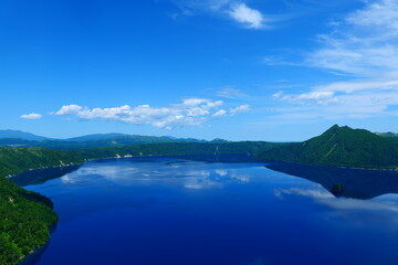 Fototapeta na wymiar 阿寒摩周国立公園。空を映す初夏の摩周湖。弟子屈、北海道、日本。6月下旬。