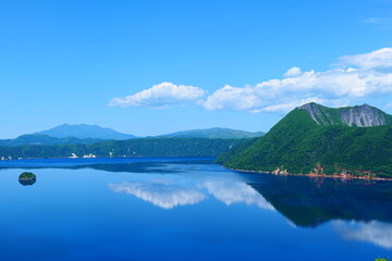 Obraz na płótnie Canvas 阿寒摩周国立公園。空を映す初夏の摩周湖。弟子屈、北海道、日本。6月下旬。