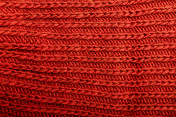 Knit red fabric texture, background or backdrop. Textile, scarf or sweater textured surface. Warm accessories, clothing, fashion concept