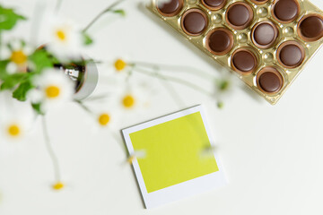 Light colorful holiday banner. Flowers on a marble background with a card and a pen. Mother's day, birthday, celebration concept, congratulations. Copy space, top view, greeting card banner.