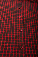 dark red checkboard pattern shirt fabric background, garment texture with buttons, vertical shot