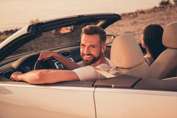 Photo of carefree pretty married couple dressed white clothes driving car smiling outdoors country...