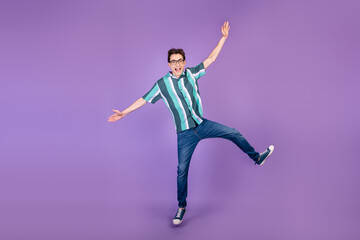 Fototapeta na wymiar Full size photo of young man jump up fooling playful have fun wear casual clothes isolated over violet color background