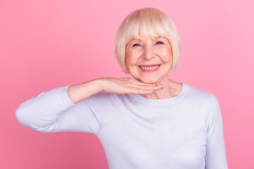 Photo of senior lovely woman hand touch chin collagen plastic lifting procedure isolated over pink color background