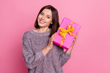 Portrait of attractive cheerful girl holding in hands festal gift 8 March isolated over pink pastel...