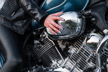 Close-up of a female hand on a motorcycle.