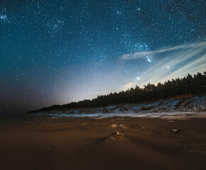 Night skyscape of a starry sky at the seashore. Stars constellations and Milky Way galaxies in the...