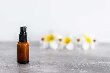 natural beauty and organic ingredients in skincare, amber skincare bottle with flowers in the background