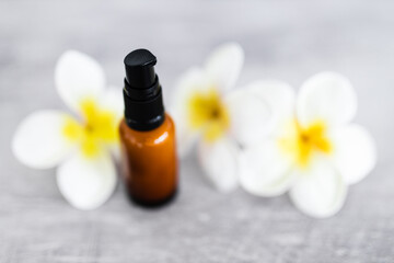 Fototapeta na wymiar natural beauty and organic ingredients in skincare, amber skincare bottle with flowers in the background
