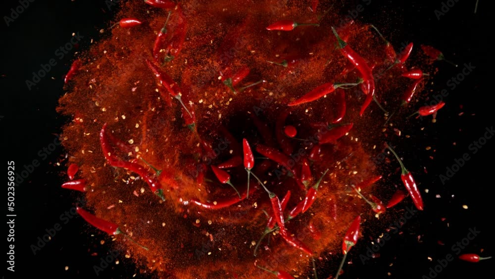 Poster super slow motion of rotating chilli peppers isolated on black. overhead view, filmed on high speed 