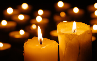 Two burning candles in the dark