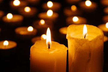 Two burning candles in the dark