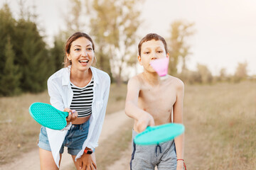 Mom and child boy playing badminton or beach tennis and have a good time and leisure outdoors at...