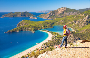 Fototapeta na wymiar Sporty hiking girl over Oludeniz lagoon in sea landscape view of beach