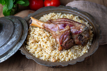 Turkish foods; lamb shank tandoori on bulgur wheat rice (Turkish name; bulgur bugday pilavi kuzu incik tandir)