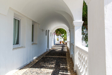 Arched corridor with columns in a traditional Greek white house.