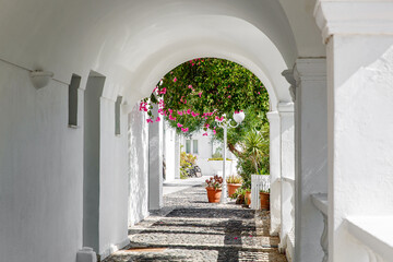 Arched corridor with columns in a traditional Greek white house.