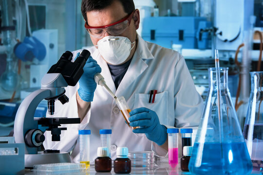 Scientist working in microscope with chemical material samples in biotechnology lab. Scientist Researcher examining test tube in the Medical Research Laboratory