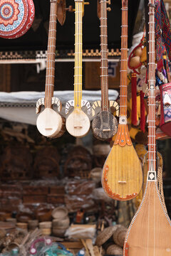 Vertical closeup of string musical instruments hanging in the souvenir shop. Selected focus.