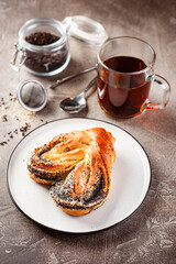 Sweet pies or buns made from yeast dough on platter and glass of tea