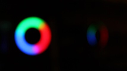 A rotating blurred light ring of three sectors or segments of blue, green and red color. Progress indicator. Background illumination. LED lamp effect. - Powered by Adobe