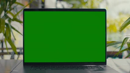 Green Screen laptop on table with green plants on background