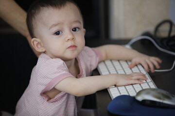 Un bébé touche un clavier d'ordinateur