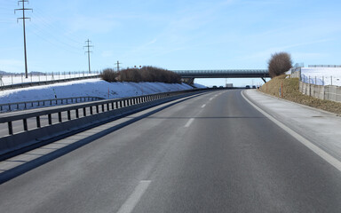 Autoroute suisse avec neige dans la campagne et pont