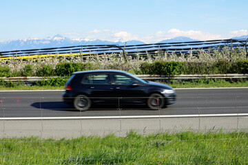 Une voiture de profil floue roule sur l'autoroute