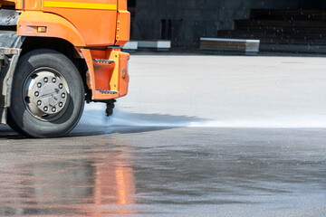 A cleaning machine washes a city street