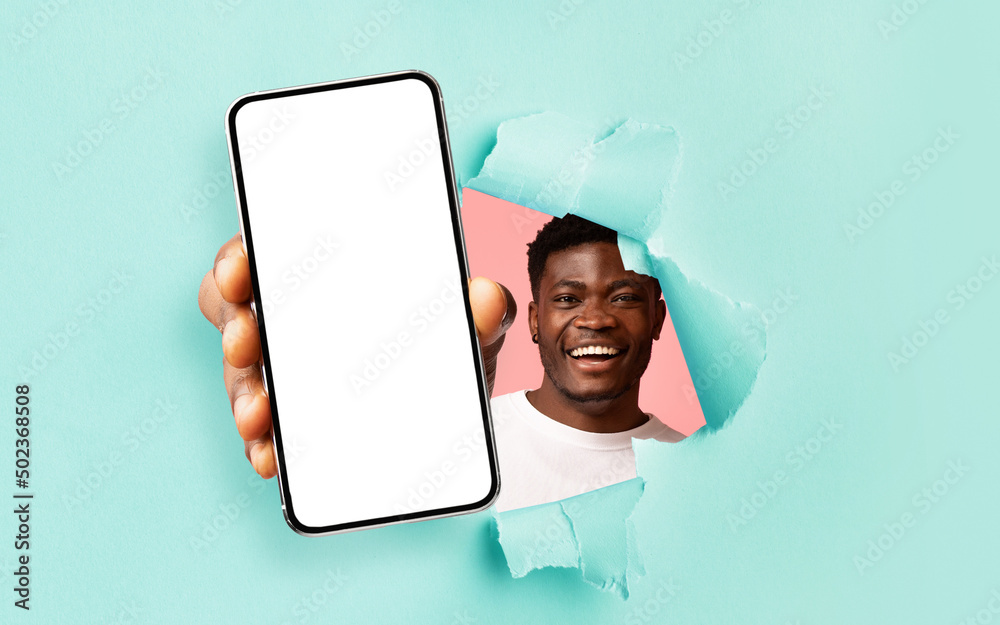 Poster black guy showing white empty smartphone screen through torn paper