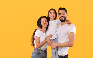 Arabic Parents And Daughter Embracing Together Posing On Yellow Background