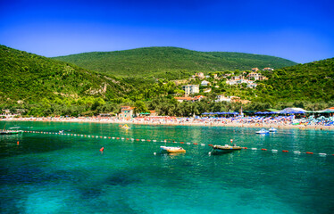 Vacationers swimming in crystal clear and turquoise water of Adriatic sea in Zanjice Beach with a...