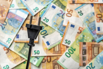 Appliance power plug against euro banknotes background with copy space. Power crisis and inflation....