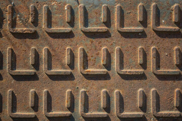 evocative image of rusty surface texture with square shape embossed patterns
