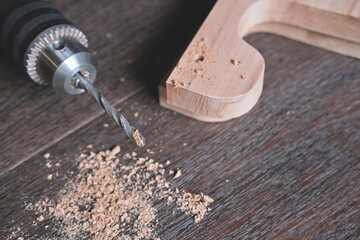 Drill, dust and natural wooden planks as details for construction of handcraft furniture