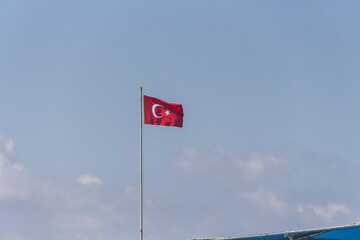 Turkey, Alanya, 30.08.2021: Turkish flag on a long flagpole fluttering in the wind