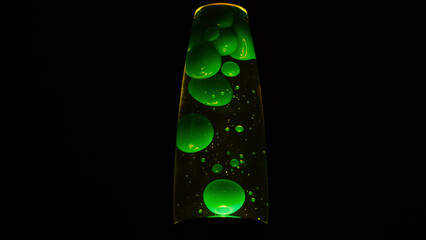 Green lava lamp on black background. Concept. Beautiful neon-lit lava lamp in total darkness. Retro neon night light with moving bubbles. Lava lamp