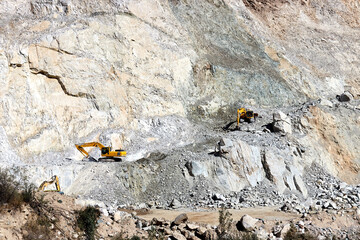 excavators working on the slope of the cliff