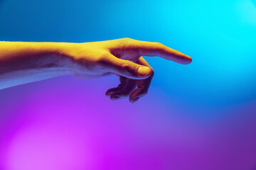 Studio shot of aethentic human hand isolated on gradient purple-blue background in neon light. Concept of human relation, community, togetherness