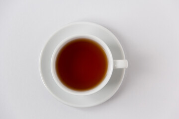 Cup of black tea top view on a white background. 