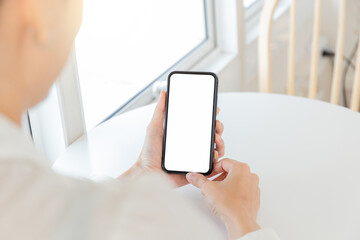 cell phone blank white screen mockup.hand holding texting using mobile on desk at office.background empty space for advertise.work people contact marketing business,technology