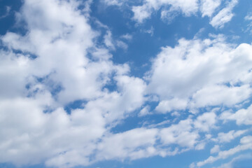 White cumulus clouds on a clear blue sky.